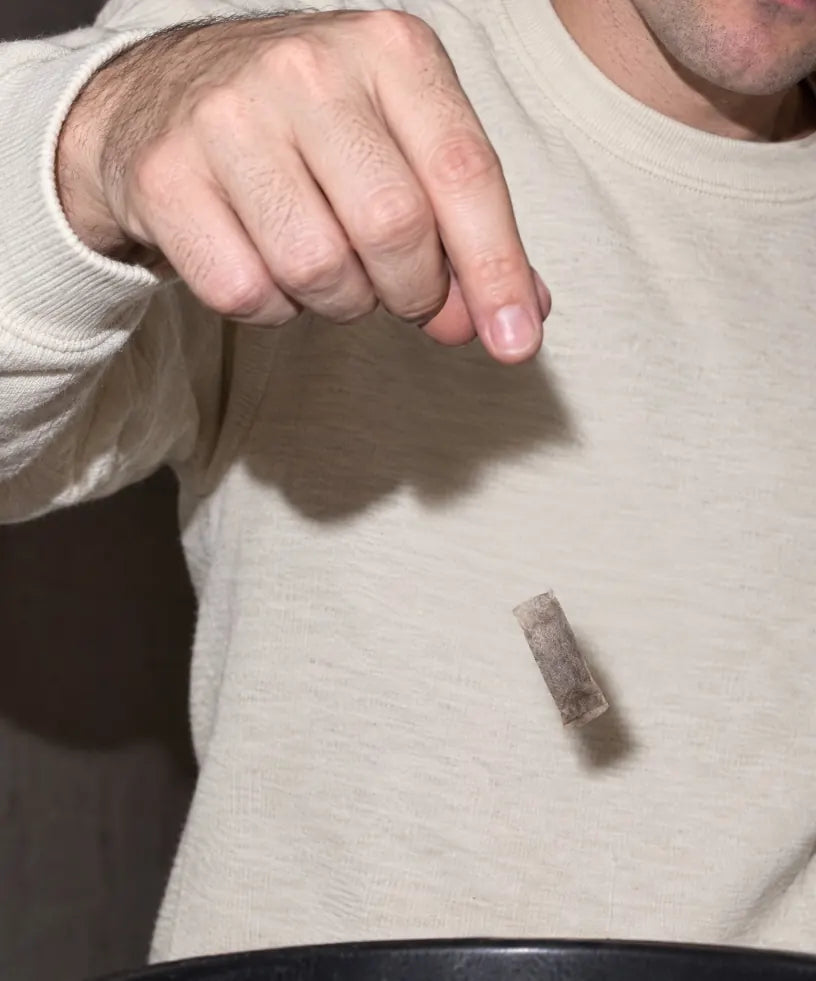 Ein benutzter Pouch wird in einen Mülleimer geworfen